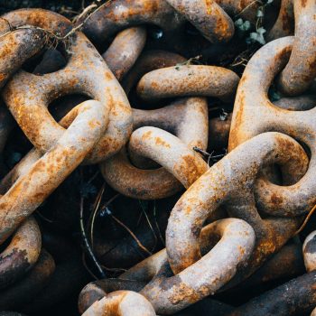 A closeup of old rusty metallic chains under the lights